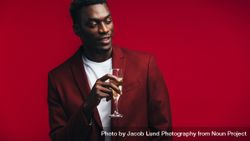 Stylish Black man with a glass of champagne looking away at copy space 5nVXM5