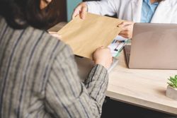 Businesswoman handing a file to an employee at the office