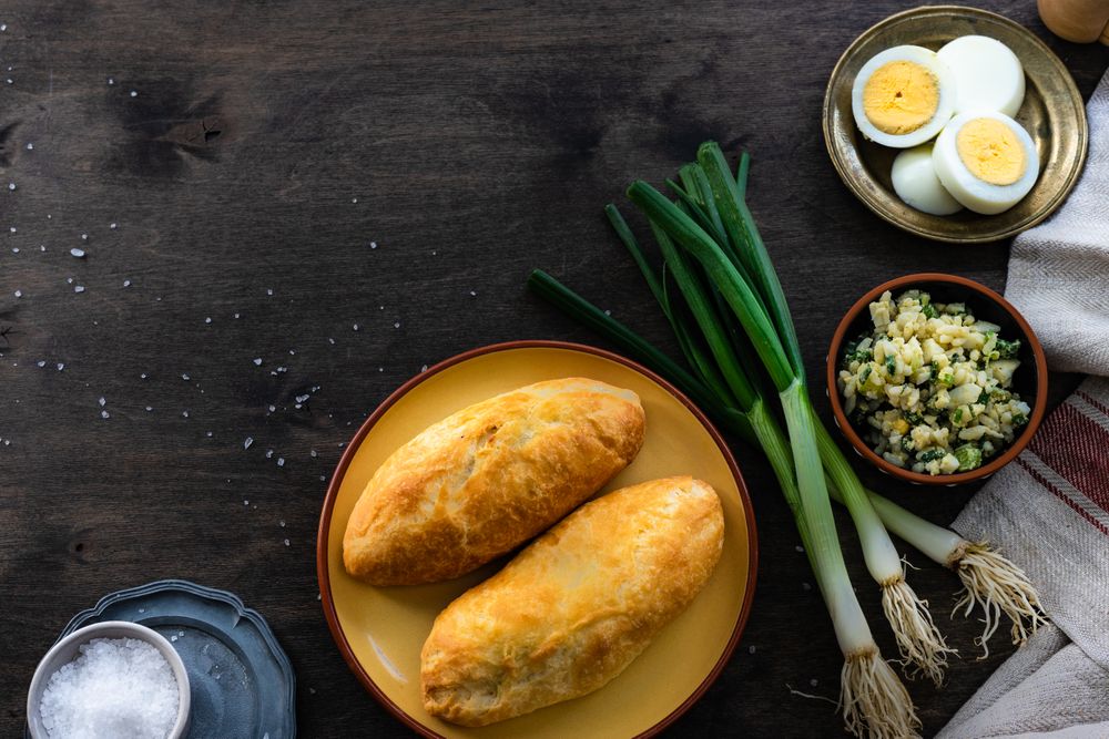Top view of traditional Georgian pies with eggs, rice and green onion with copy space