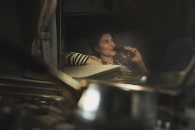 Reflection of woman drinking from bottle