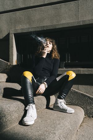 Young woman smoking cigarette in the street