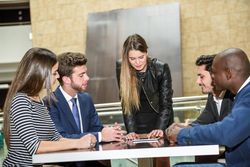 Woman using a digital tablet leading her corporate team during a meeting