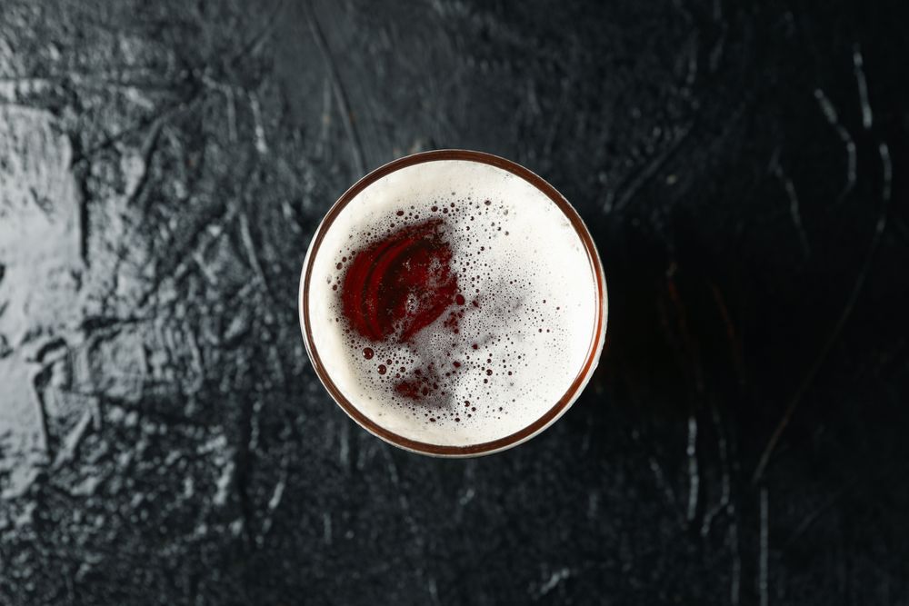 Glass of beer on background, top view