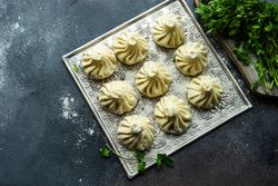Top view of trey of Georgian khinkali dumplings with cilantro garnish and copy space