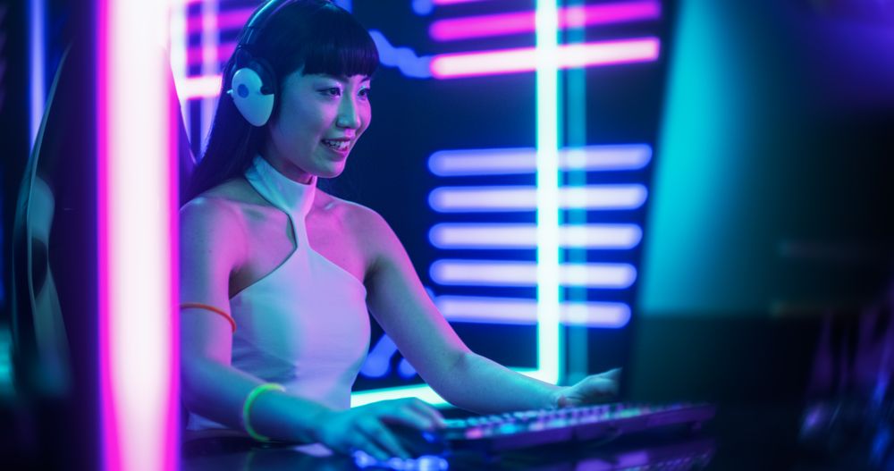 Smiling Streamer or Video Gamer Playing Games and Chatting with Internet Followers in a Futuristic Neon Studio