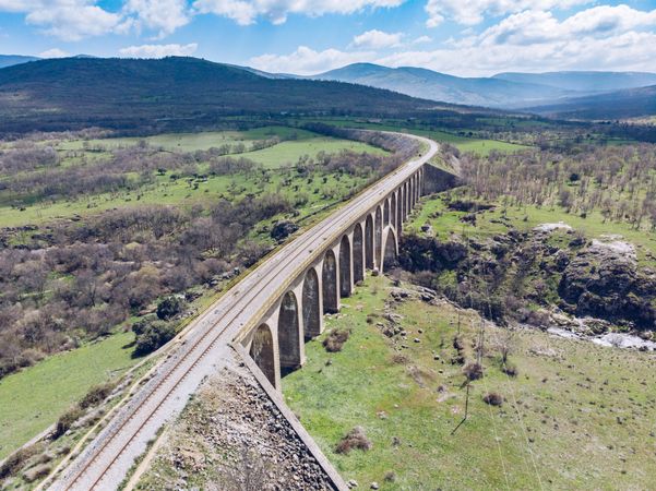 Concrete bridge over mountain river at picturesque green valley