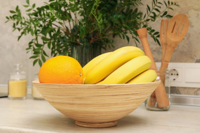 Kitchen interior with supplies, fruits and plant