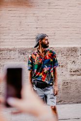 Faceless female taking photo of bearded man