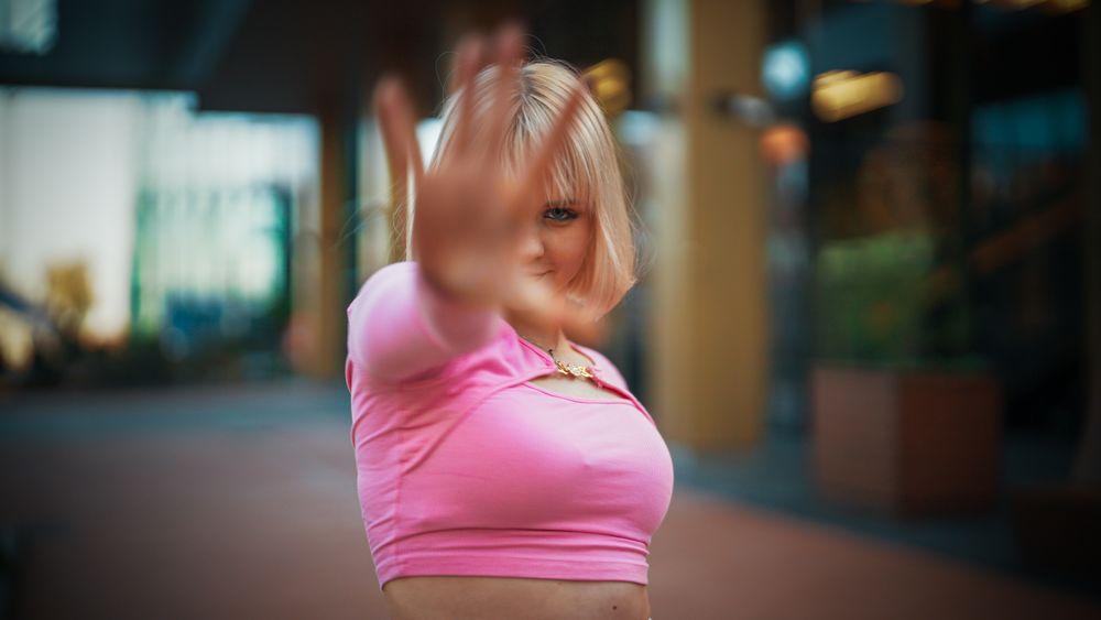 Vibrant Young Woman In A Pink Top Joyfully Dancing On A City Street