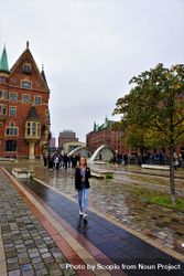 Blonde woman standing near brown building in Hamburg, Germany 4Zrax4