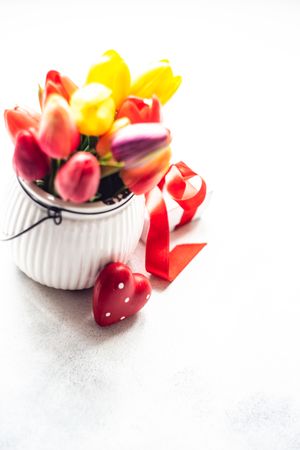 Small vase of tulips and heart ornaments