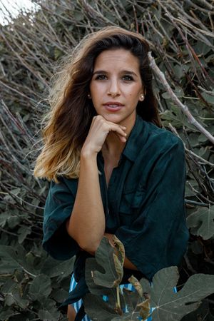 Tranquil woman in stylish clothing delighting in forest