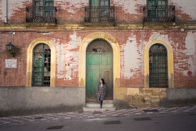 Woman on street with aged building