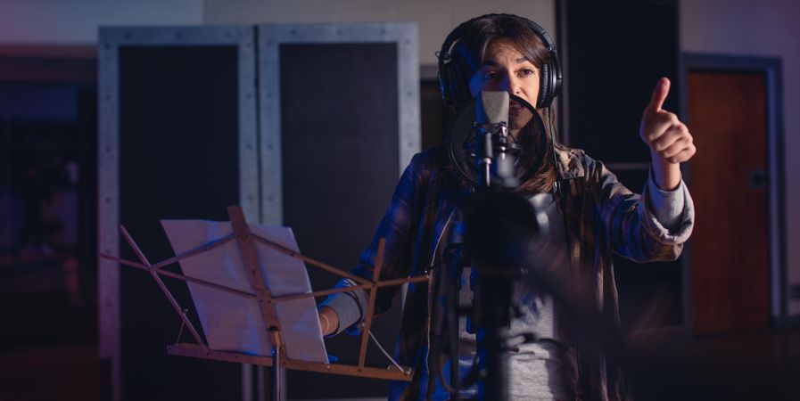 Woman recording a song for her new album in recording studio