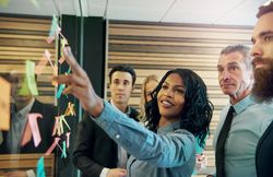 Diverse group of colleagues working with sticky notes in an office
