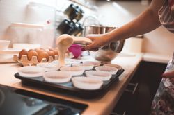 Cropped image of a person making cupcakes at kitchen