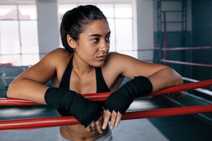 Female boxer inside a boxing ring looking away