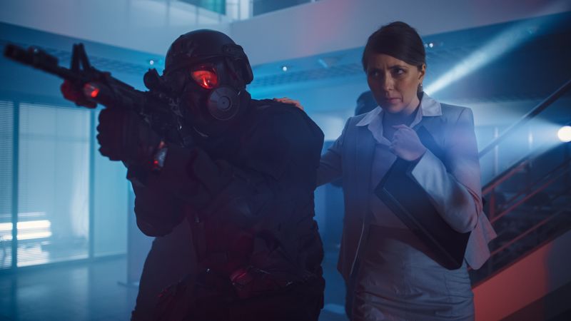 Masked Squad of Armed SWAT Police Officers Rescue a Female Hostage in a Dark Seized Office Building with Desks and Computers.