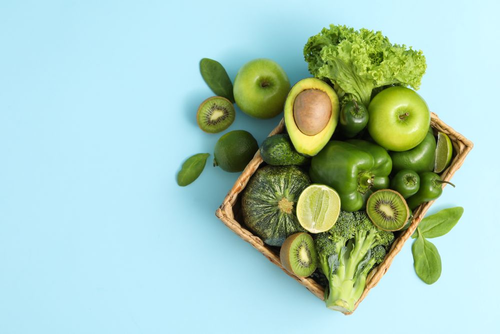 Basket with vegetable and fruits on blue background