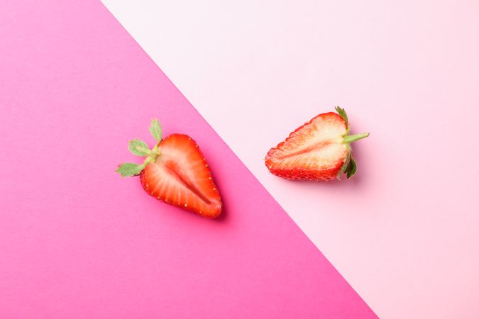 Half of strawberries on two color background, space for text. Summer sweet fruits and berries