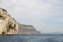 Limestone rocks and boats sailing in sea