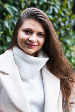 Happy stylish woman with white sweater resting in park