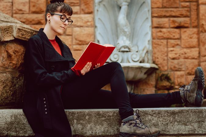 Young woman reading book on steps