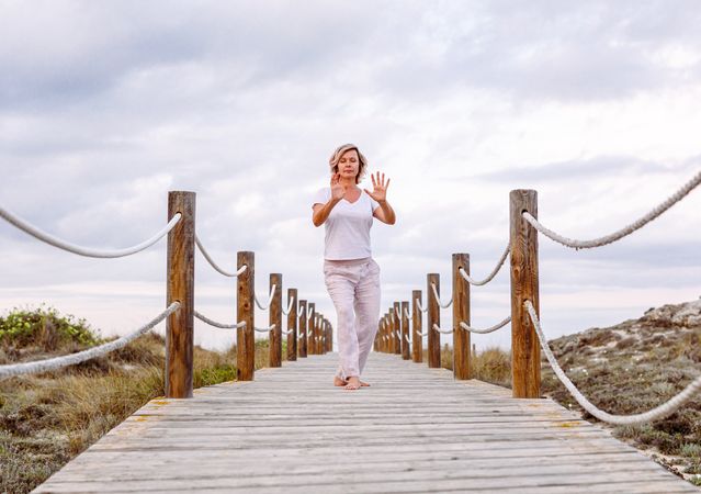 Barefoot woman exercising on wooden path
