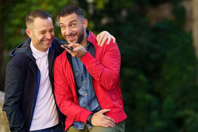 Fun male couple speaking on phone