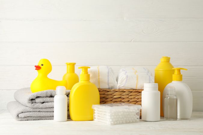 Baby hygiene accessories on light wooden background