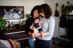 Two women with their curious baby girl at home