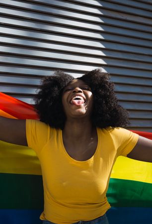 Black woman posing happily with the LGBT flag