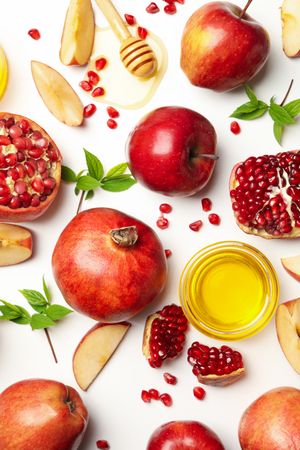 Top view of fresh apples and pomegranates with honey on side with copy space
