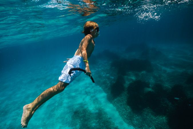 Boy in diving mask swimming underwater