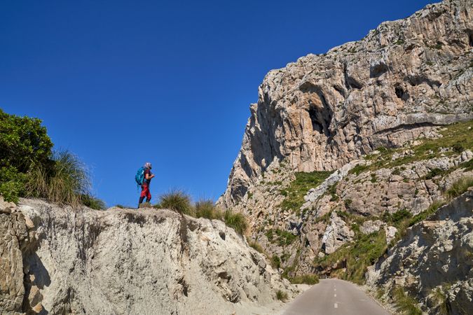 Unrecognizable man with backpack standing in mountains