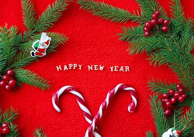 Christmas tree and candy on a red background with the words Happy New Year Postcard