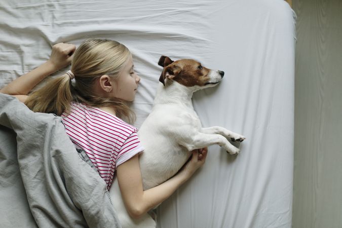 Top view of girl sleeping with her dog