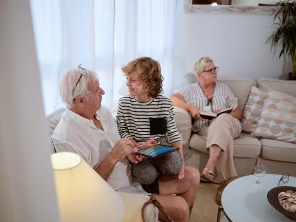 Grandson with grandfather browsing tablet together