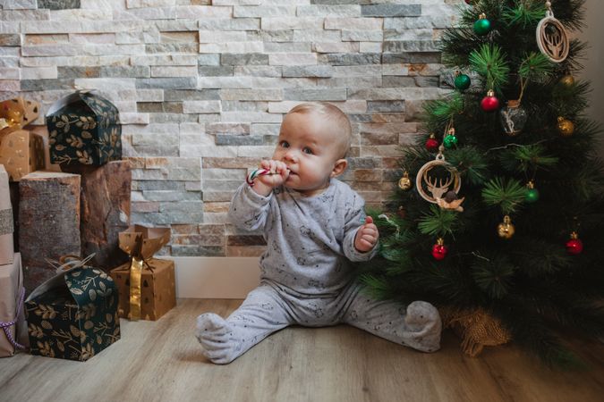 Cute baby playing with Christmas tree baubles
