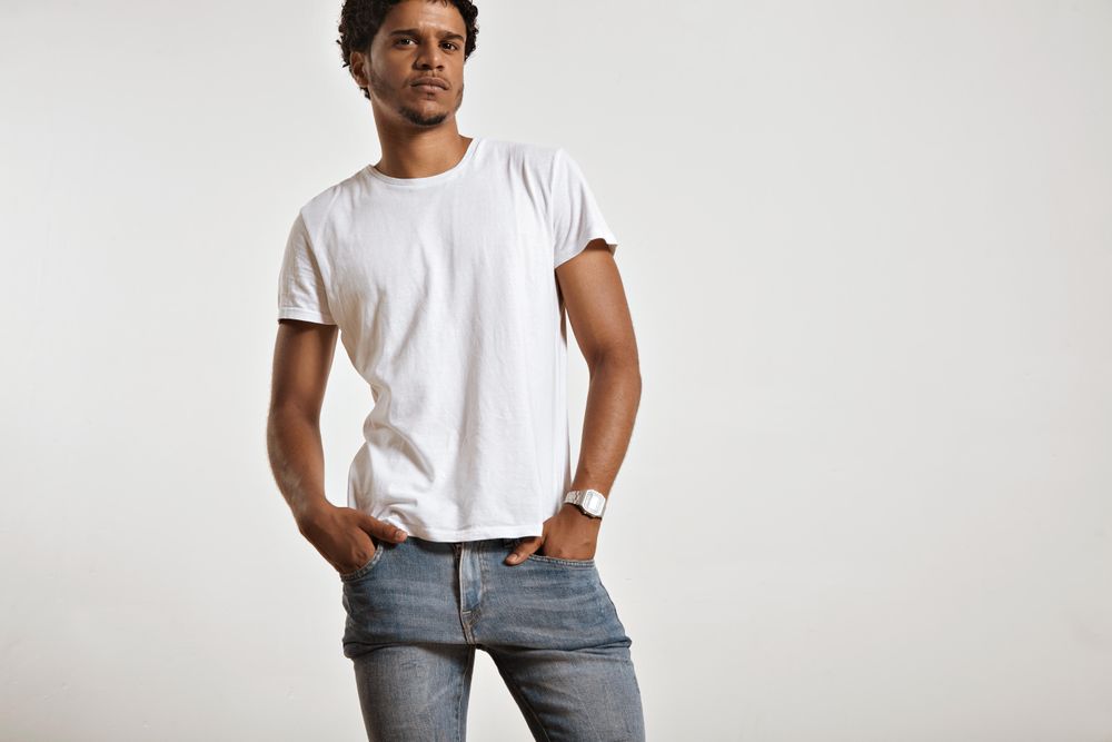 Man with hands in jean pockets looking at camera in studio shoot