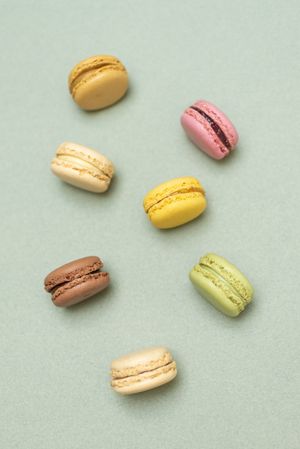 Top view of pastel macaroon desserts on a marble background