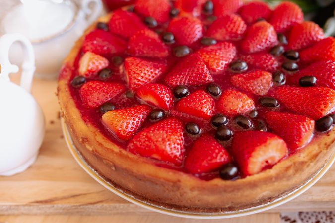 from above a strawberries cake on table with coffee and milk