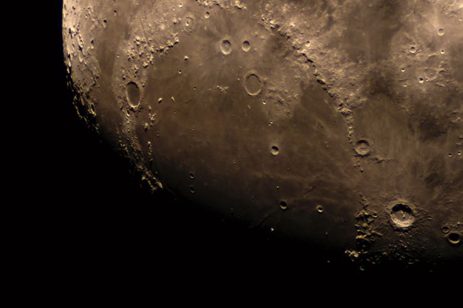 Close-up telescopic view of lunar craters and rugged mare region