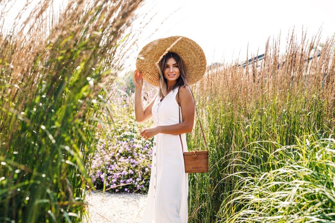 Calm happy female in a field outside in sundress and sunhat