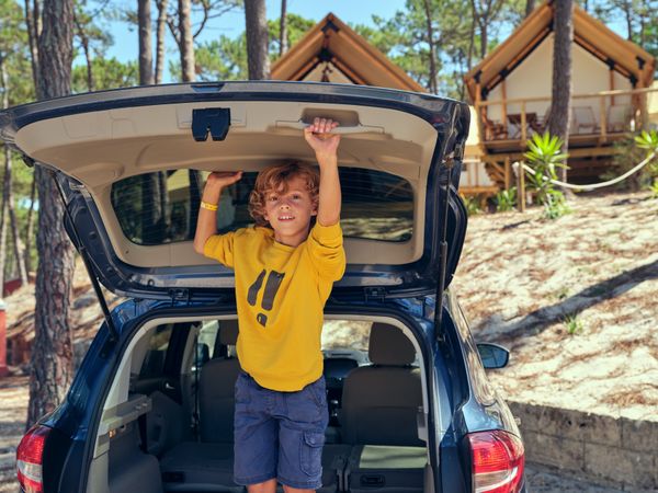 Boy playing in trunk near glamping campsite