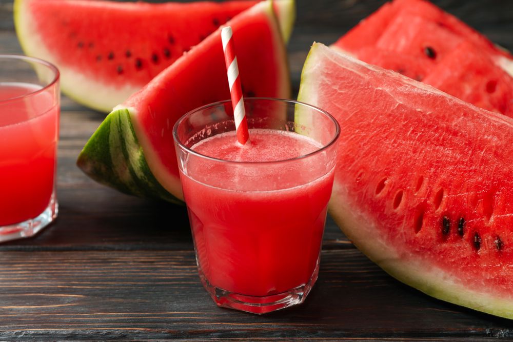 Composition with watermelon slices and juice on wooden background. Summer fruit