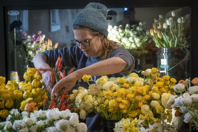 Copake, New York - May 19, 2022: Woman sorting flowers in shop