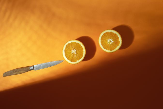 Sliced oranges with knife