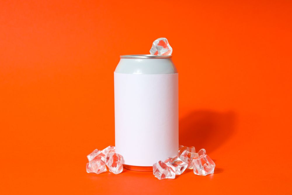 Blank can with ice cubes on orange background