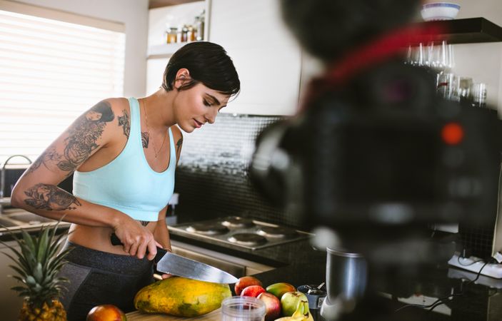 Female working on food blogger concept with fruits in kitchen